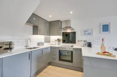 a kitchen with white counter tops and appliances at 1 Bed in Porthleven oc-portb in Porthleven