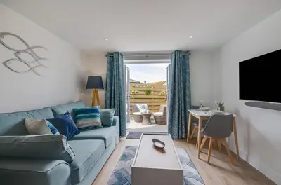 a living room with a blue couch and a table at 1 Bed in Porthleven oc-portb in Porthleven