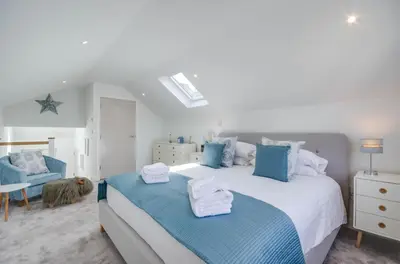 a bedroom with a large bed with blue and white pillows at 1 Bed in Porthleven oc-portb in Porthleven