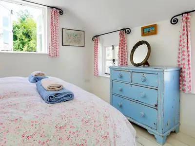 a bedroom with a blue dresser and a bed at 4 Bed in Rock oc-r27255 in Saint Minver