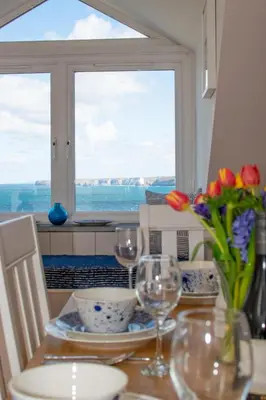 a dining room table with a view of the ocean at 3 Bed in Port Isaac oc-secrft in Port Isaac