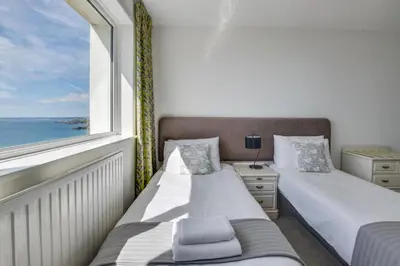 two beds in a room with a window at 5 Bed in Praa Sands oc-seacro in Praa Sands
