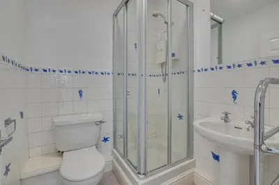 a bathroom with a shower and a toilet and a sink at 5 Bed in Praa Sands oc-seacro in Praa Sands