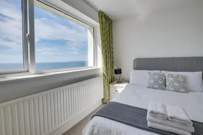 a bedroom with a bed and a large window at 5 Bed in Praa Sands oc-seacro in Praa Sands