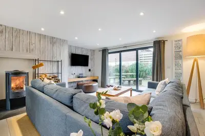 a living room with a blue couch and a fireplace at 3 Bed in Trevone oc-stcad in Padstow