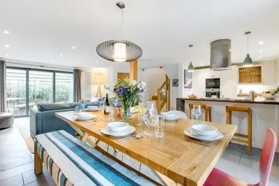 a dining room and living room with a wooden table at 3 Bed in Trevone oc-stcad in Padstow