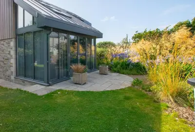 a garden with a conservatory with plants at 3 Bed in Trevone oc-stcad in Padstow