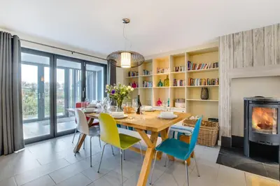 a dining room with a table and chairs and a fireplace at 3 Bed in Trevone oc-stcad in Padstow