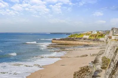 a view of a beach with the ocean and buildings at 2 Bed in Porthleven oc-stmich in Porthleven