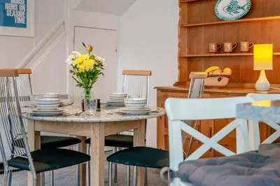 a dining room with a table with plates and flowers on it at 2 Bed in St. Teath oc-shilli in Saint Teath