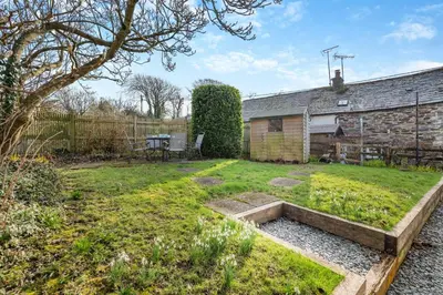 a garden with a table and a brick building at 2 Bed in St. Teath oc-shilli in Saint Teath