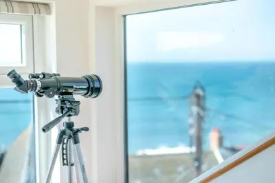 a camera on a tripod in front of a window at 2 Bed in Porthleven oc-suffol in Porthleven