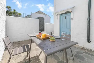 a wooden table with a tray of food and two chairs at 2 Bed in Porthleven oc-suffol in Porthleven