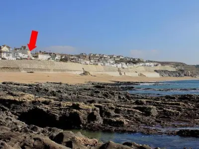 a red kite flying over a rocky beach at 2 Bed in Porthleven oc-suffol in Porthleven
