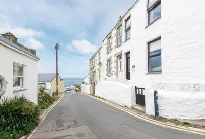 an empty street in front of a white building at 2 Bed in Porthleven oc-suffol in Porthleven