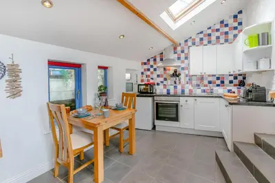 a kitchen with a wooden table and chairs at 1 Bed in Porthleven oc-smuggl in Porthleven