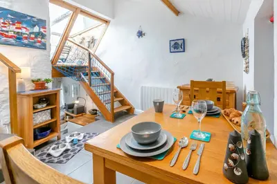 a dining room with a table with plates and wine glasses at 1 Bed in Porthleven oc-smuggl in Porthleven
