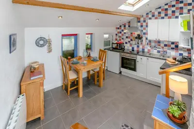 a kitchen with a table and chairs in a room at 1 Bed in Porthleven oc-smuggl in Porthleven
