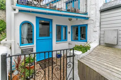 a house with a blue door and a balcony at 1 Bed in Porthleven oc-smuggl in Porthleven