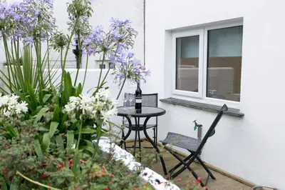a patio with a table and chairs and flowers at 2 Bed in Porthleven oc-seasal in Porthleven