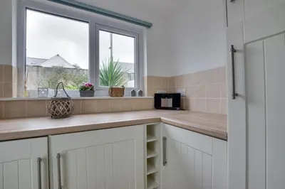 a kitchen with white cabinets and a window at 2 Bed in Porthleven oc-seasal in Porthleven