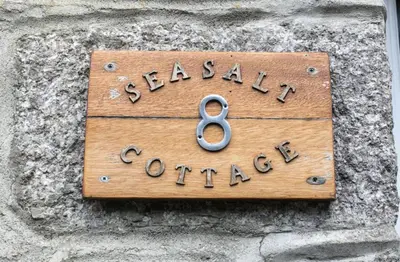 a wooden sign on a stone wall with the wordalexual journey at 2 Bed in Porthleven oc-seasal in Porthleven