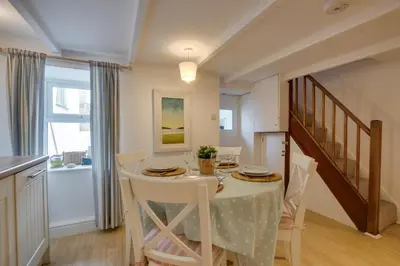 a kitchen and dining room with a table and chairs at 2 Bed in Porthleven oc-seasal in Porthleven