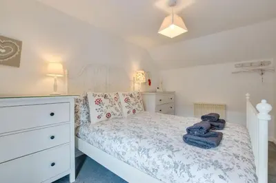 a bedroom with a white bed and a dresser at 2 Bed in Porthleven oc-seasal in Porthleven