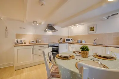 a kitchen with a table and chairs in a kitchen at 2 Bed in Porthleven oc-seasal in Porthleven