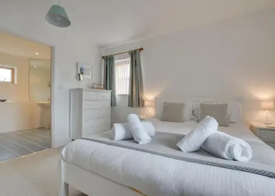 a bedroom with a white bed with white pillows at 2 Bed in Porthleven oc-shorse in Porthleven