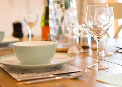 a wooden table with a bowl and a wine glass at 2 Bed in Porthleven oc-shorse in Porthleven
