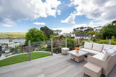 a patio with a couch and chairs on a wooden deck at 3 Bed in Fowey oc-tidewa in Fowey