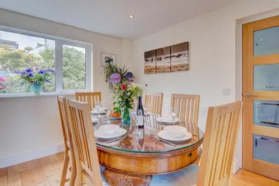 a dining room with a glass table and chairs at 3 Bed in Fowey oc-tidewa in Fowey