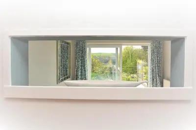 a mirror hanging on a wall with a window at 3 Bed in Fowey oc-tidewa in Fowey