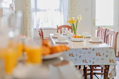 a table with a plate of food and flowers on it at 3 Bed in St. Issey oc-v27518 in Saint Issey