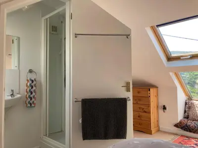 a bathroom with a glass shower and a sink at 'Anchor Point', Porthtowan in Porthtowan