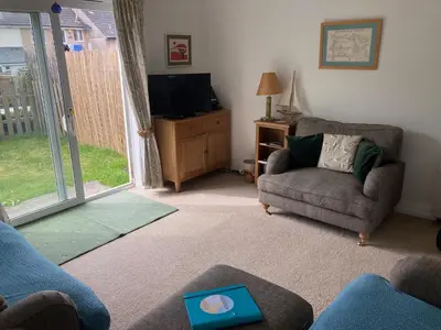 a living room with a couch and a television at 'Anchor Point', Porthtowan in Porthtowan