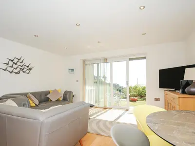 a living room with a couch and a table at Pebbles in Torpoint