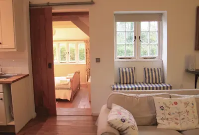 a living room with a couch and a bedroom at Owl House in Wadebridge
