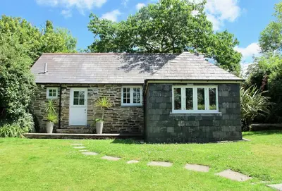 a small stone house with a grass yard at Owl House in Wadebridge