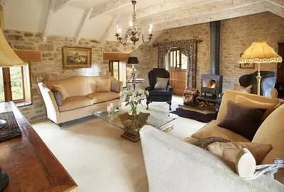 a living room filled with furniture and a fireplace at Tregadjack Barn in Crowan