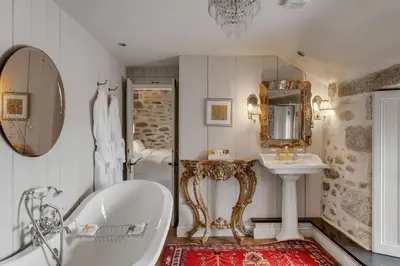 a bathroom with a tub and a sink at Tregadjack Farmhouse in Crowan