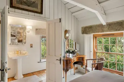 a home office with a desk and a window at Tregadjack Farmhouse in Crowan