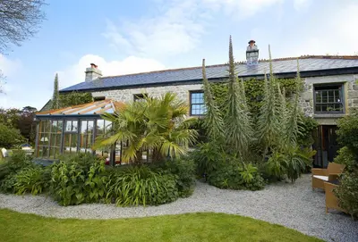 an exterior view of a house with plants at Tregadjack Farmhouse in Crowan