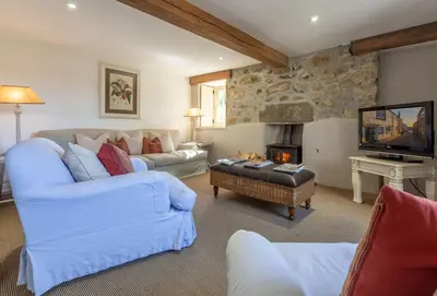 a living room with two couches and a fireplace at Bonython Farmhouse in Helston