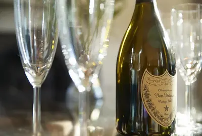a bottle of wine sitting on a table with glasses at Rosevean House in St. Agnes