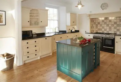 a large kitchen with a blue island in the middle at Rosevean House in St. Agnes