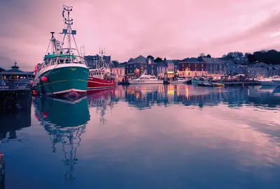 a large boat is docked in a harbor at Pelorus Cottage in St Merryn