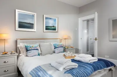 a bedroom with a bed with towels on it at Pelorus Cottage in St Merryn