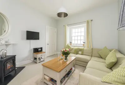 a living room with a couch and a fireplace at Sally Port Cottage in Saint Mawes